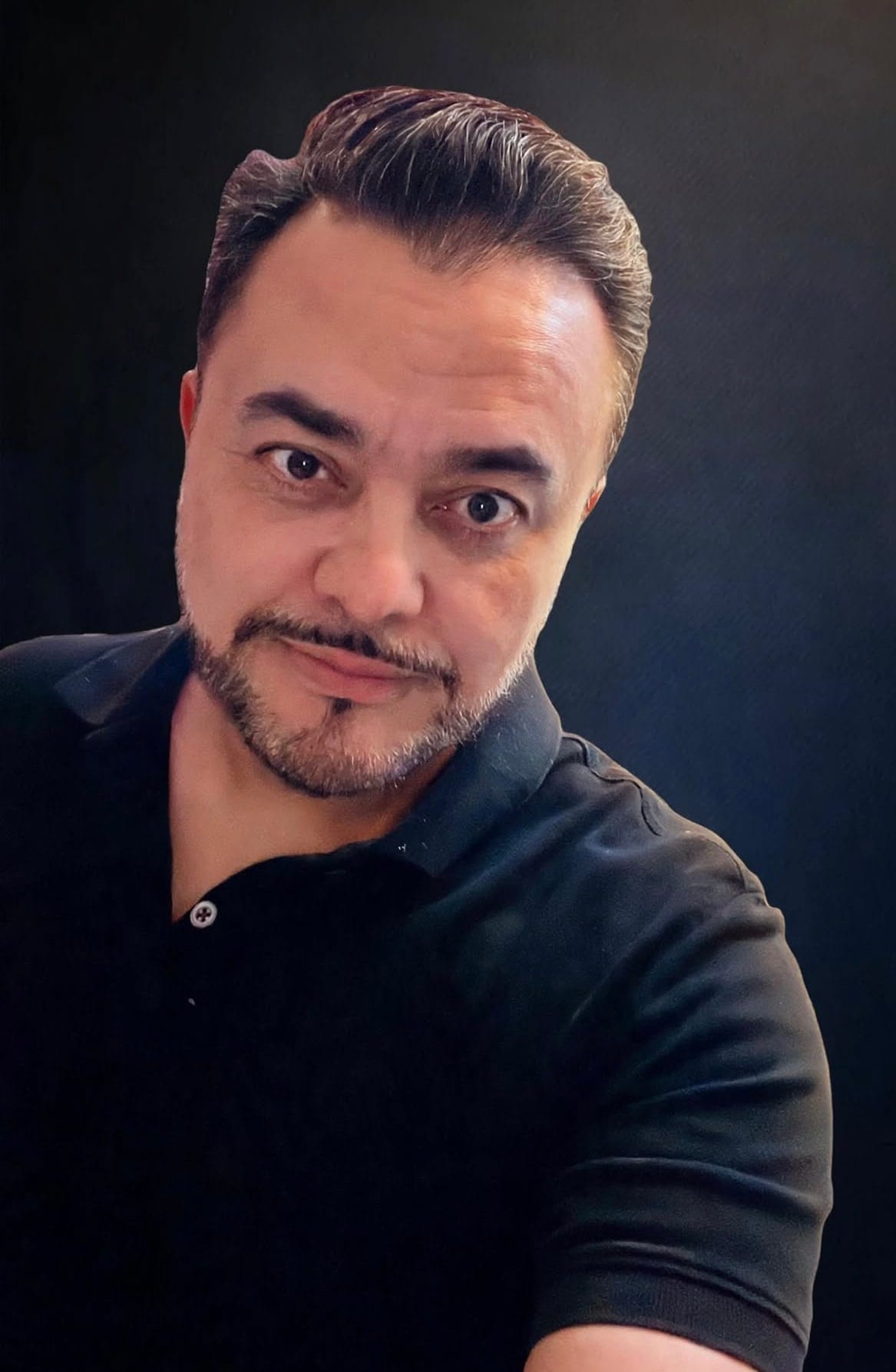 Retrato de estudio de Arturo Ordorika, saco oscuro sobre fondo teal